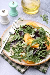 Photo of Tasty salad with arugula, blue cheese and vegetables on grey textured table, closeup