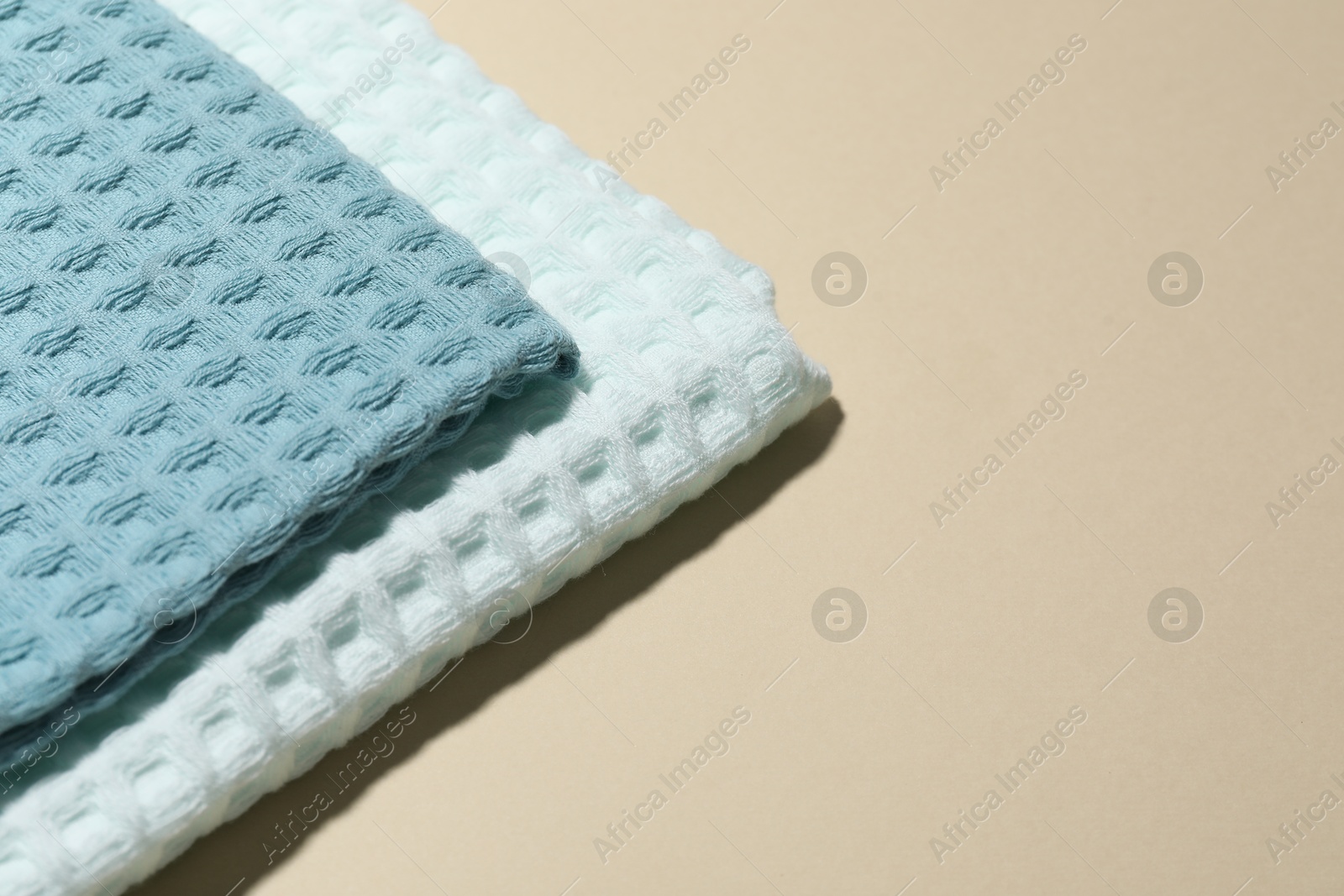 Photo of Clean waffle towels on beige background, closeup. Space for text
