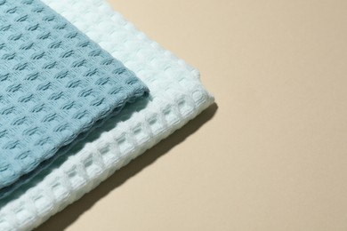 Photo of Clean waffle towels on beige background, closeup. Space for text