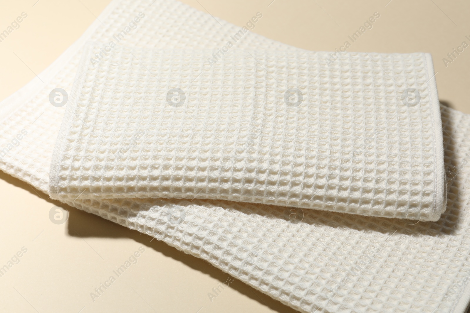 Photo of Clean waffle towels on beige background, closeup