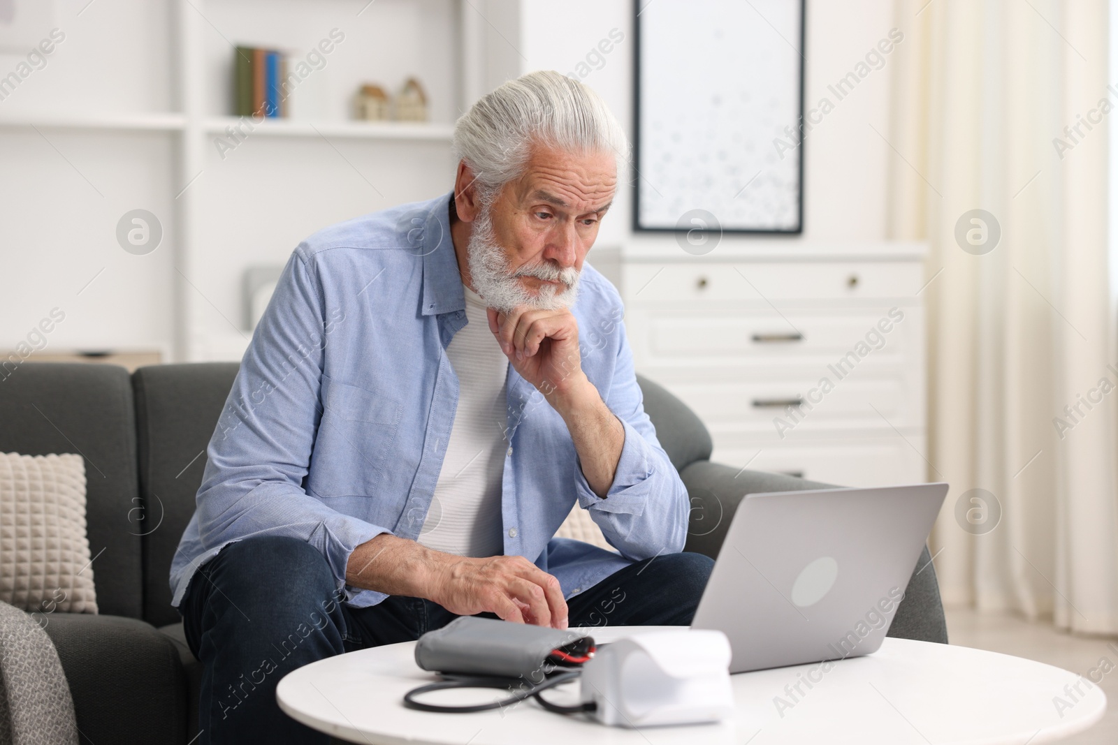 Senior man having online consultation with doctor via laptop at home Photo of Senior man having online consultation with doctor via laptop at home