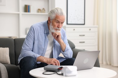 Photo of Senior man having online consultation with doctor via laptop at home
