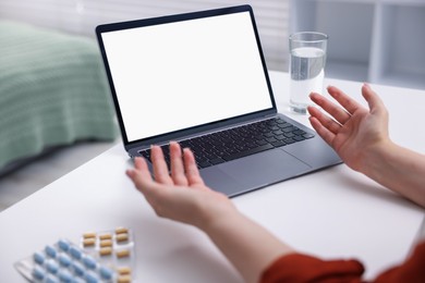 Photo of Woman having online consultation with doctor via laptop at table indoors, closeup