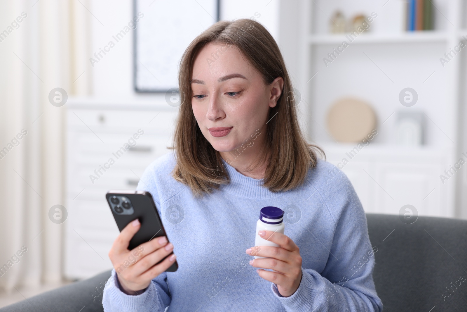 Woman with pills having online consultation with doctor via smartphone at home Photo of Woman with pills having online consultation with doctor via smartphone at home