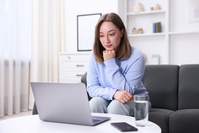 Photo of Woman having online consultation with doctor via laptop at home