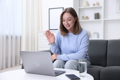 Photo of Woman having online consultation with doctor via laptop at home