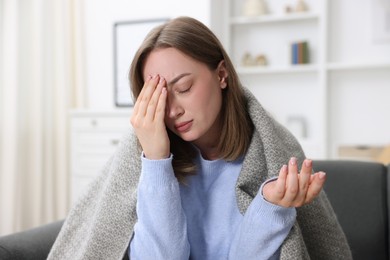 Photo of Sick woman suffering from headache at home. Online medical consultation