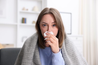 Photo of Sick woman with paper tissue at home. Online medical consultation