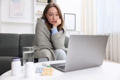 Photo of Sick woman having online consultation with doctor via laptop at home