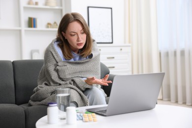 Photo of Sick woman having online consultation with doctor via laptop at home