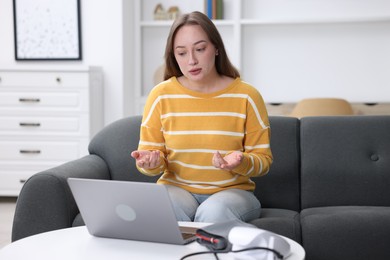 Photo of Woman having online consultation with doctor via laptop at home