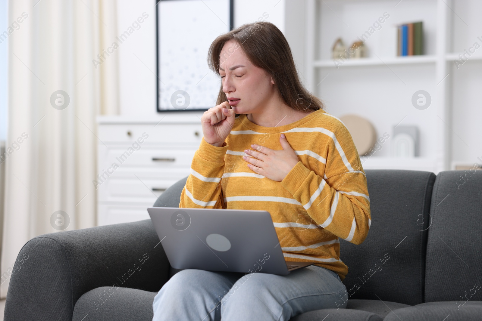 Sick woman having online consultation with doctor via laptop on sofa at home Photo of Sick woman having online consultation with doctor via laptop on sofa at home