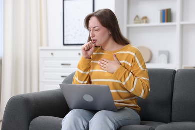 Photo of Sick woman having online consultation with doctor via laptop on sofa at home