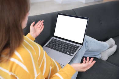 Photo of Woman having online consultation with doctor via laptop on sofa at home, closeup
