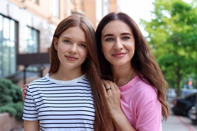 Photo of Portrait of beautiful mother and her teenage daughter on city street