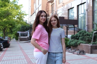 Photo of Portrait of beautiful mother and her teenage daughter on city street