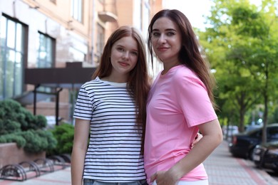 Photo of Portrait of beautiful mother and her teenage daughter on city street