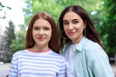 Photo of Portrait of beautiful mother and her teenage daughter on city street