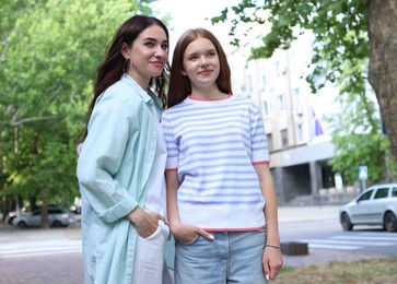 Photo of Beautiful mother and her teenage daughter on city street