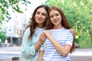 Photo of Portrait of beautiful mother and her teenage daughter on city street