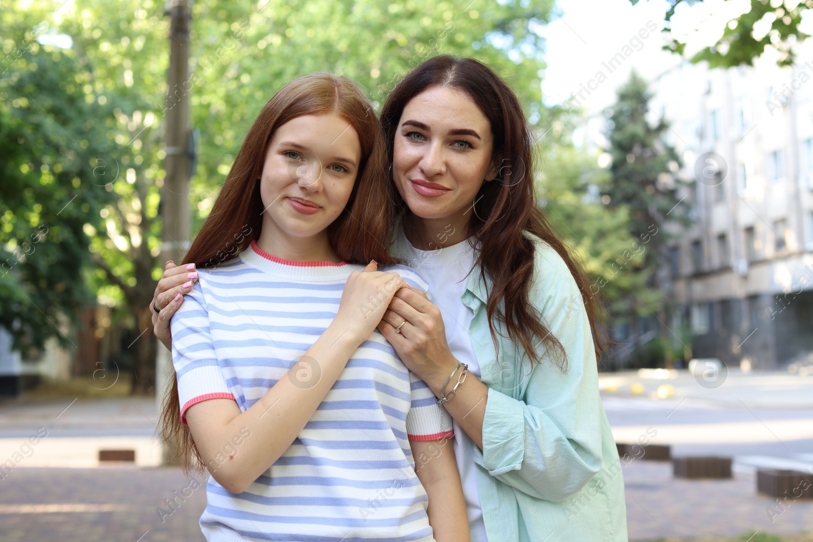 Portrait of beautiful mother and her teenage daughter on city street Photo of Portrait of beautiful mother and her teenage daughter on city street