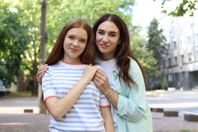 Photo of Portrait of beautiful mother and her teenage daughter on city street