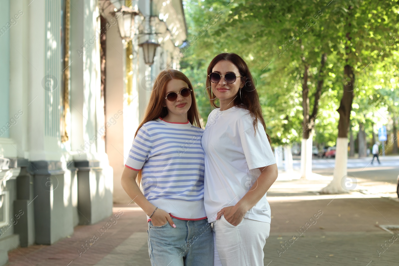 Portrait of beautiful mother and her teenage daughter in sunglasses on city street Photo of Portrait of beautiful mother and her teenage daughter in sunglasses on city street