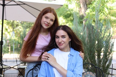 Photo of Portrait of beautiful mother and her teenage daughter in outdoor cafe