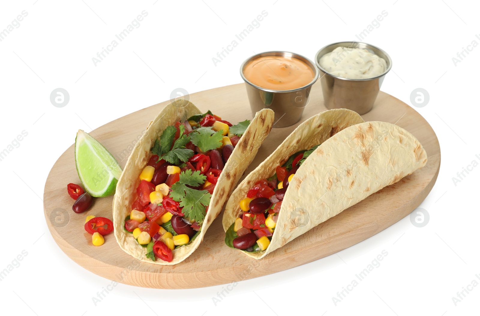 Photo of Tasty vegetarian tacos with beans, vegetables, sauces and lime isolated on white