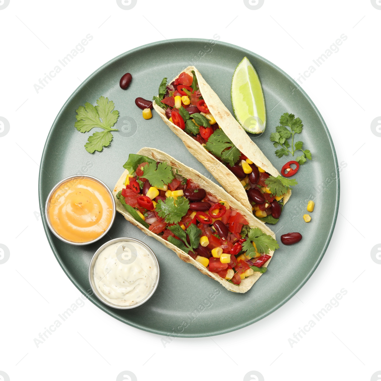Photo of Tasty vegetarian tacos with beans, vegetables, sauces and lime isolated on white, top view