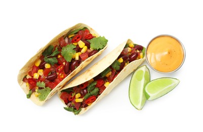Photo of Tasty vegetarian tacos with beans, vegetables, sauce and lime isolated on white, top view