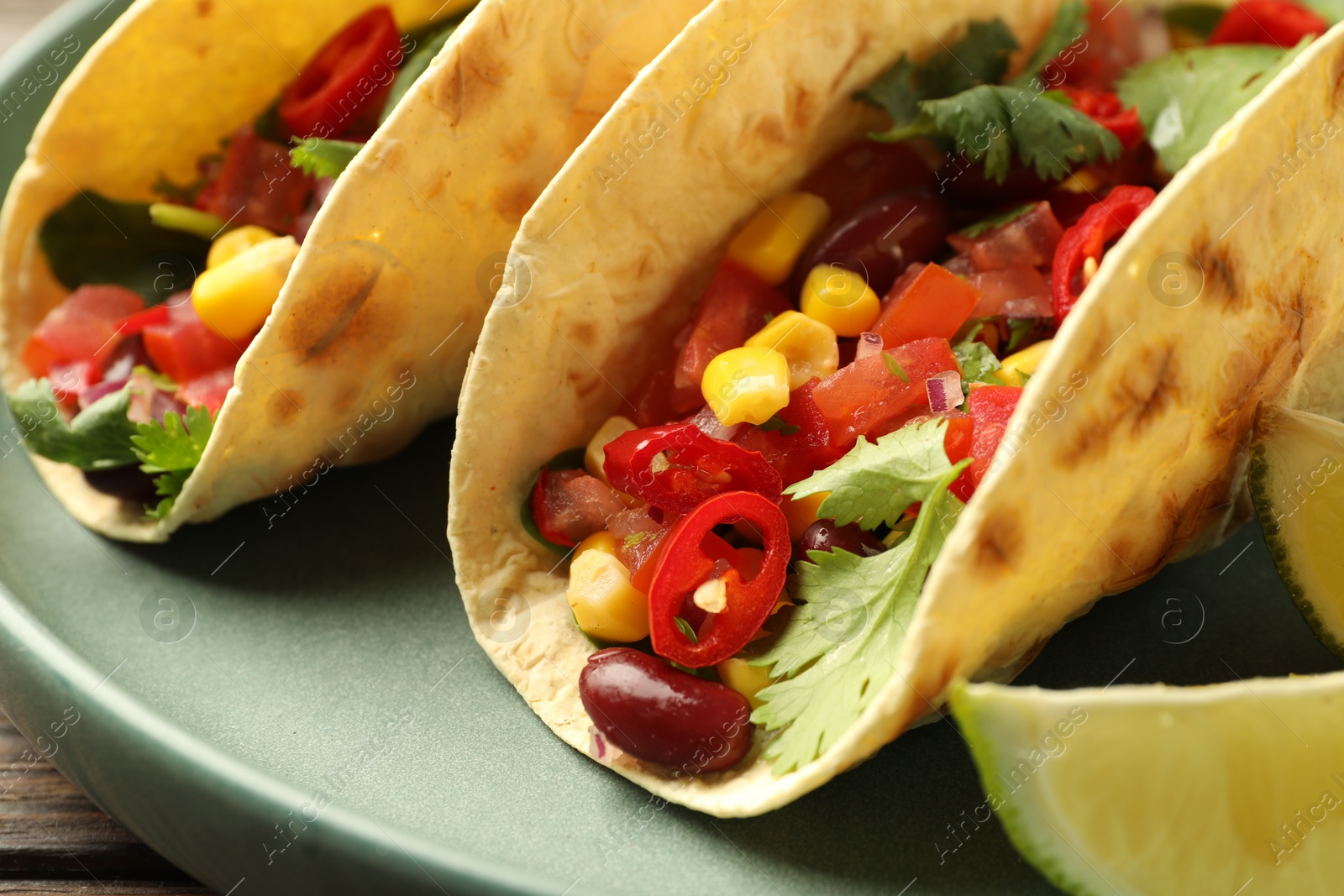 Photo of Tasty vegetarian tacos served on table, closeup