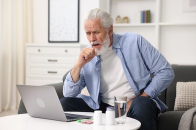 Photo of Senior man having online consultation with doctor via laptop at home