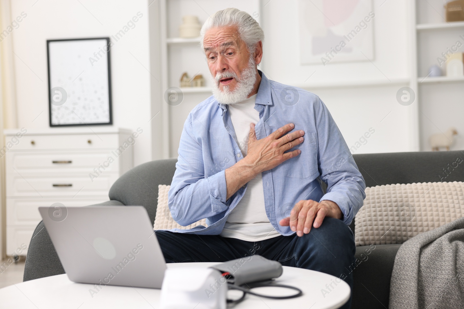 Senior man having online consultation with doctor via laptop at home Photo of Senior man having online consultation with doctor via laptop at home