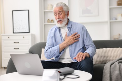 Photo of Senior man having online consultation with doctor via laptop at home