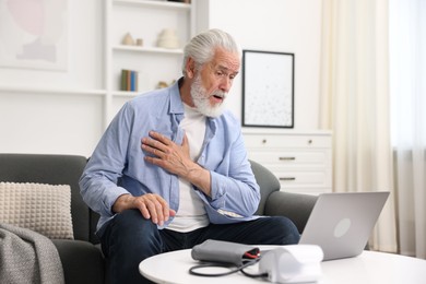 Photo of Senior man having online consultation with doctor via laptop at home