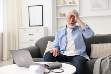 Photo of Senior man having online consultation with doctor via laptop at home