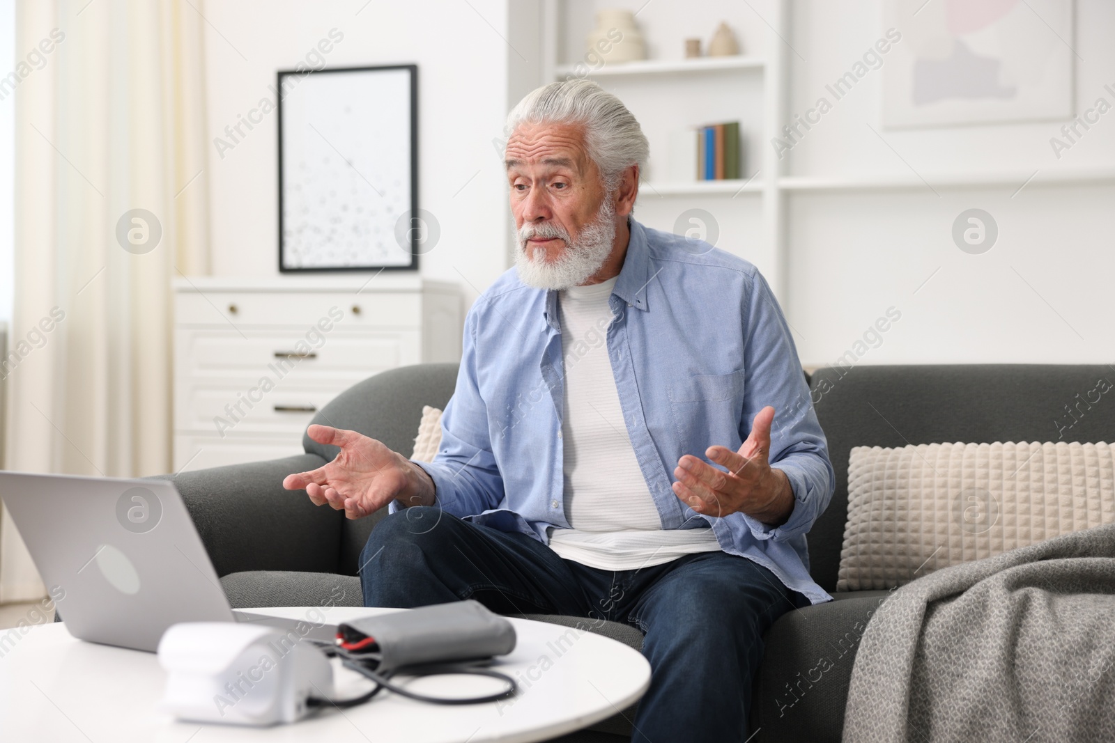 Senior man having online consultation with doctor via laptop at home Photo of Senior man having online consultation with doctor via laptop at home
