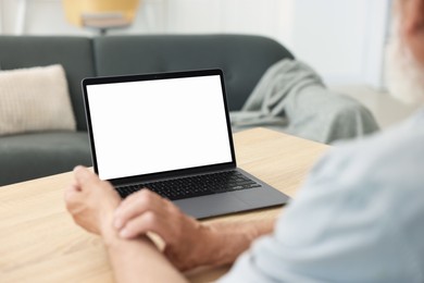 Photo of Senior man having online consultation with doctor via laptop at table indoors, closeup
