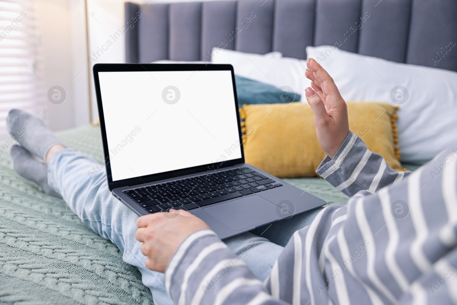 Photo of Woman having online consultation with doctor via laptop on bed at home, closeup