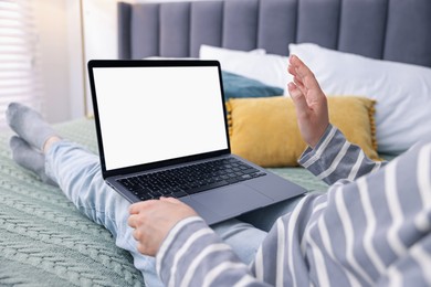 Photo of Woman having online consultation with doctor via laptop on bed at home, closeup