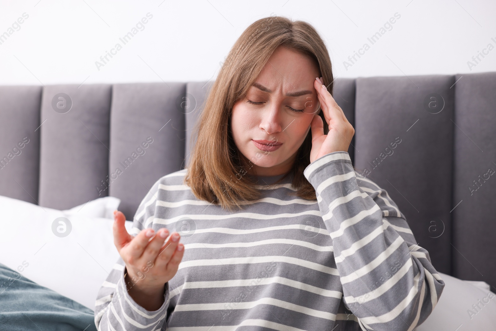 Woman suffering from headache at home. Online medical consultation Photo of Woman suffering from headache at home. Online medical consultation