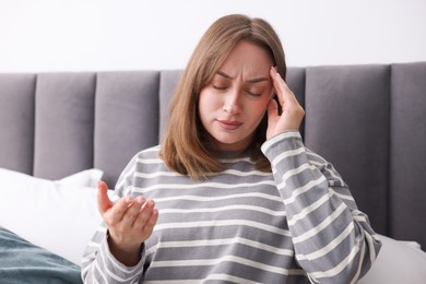 Photo of Woman suffering from headache at home. Online medical consultation