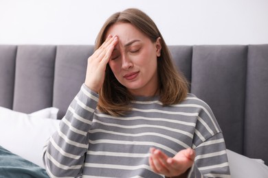 Photo of Woman suffering from headache at home. Online medical consultation