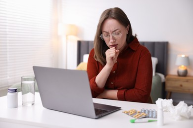 Photo of Woman having online consultation with doctor via laptop at table indoors