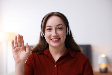 Photo of Woman in headphones having online consultation with doctor at home