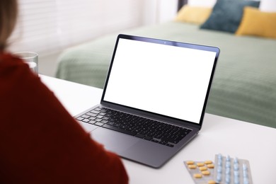 Photo of Woman having online consultation with doctor via laptop at table indoors, closeup