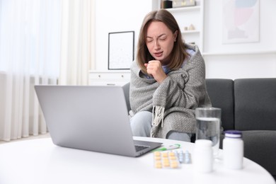 Photo of Sick woman having online consultation with doctor via laptop at home