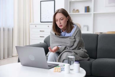 Photo of Sick woman having online consultation with doctor via laptop at home