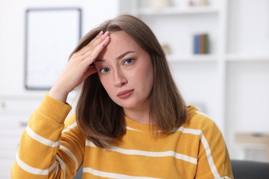 Photo of Sick woman suffering from headache at home. Online medical consultation